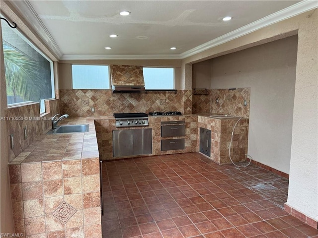 kitchen featuring custom exhaust hood, dark tile patterned flooring, crown molding, and sink