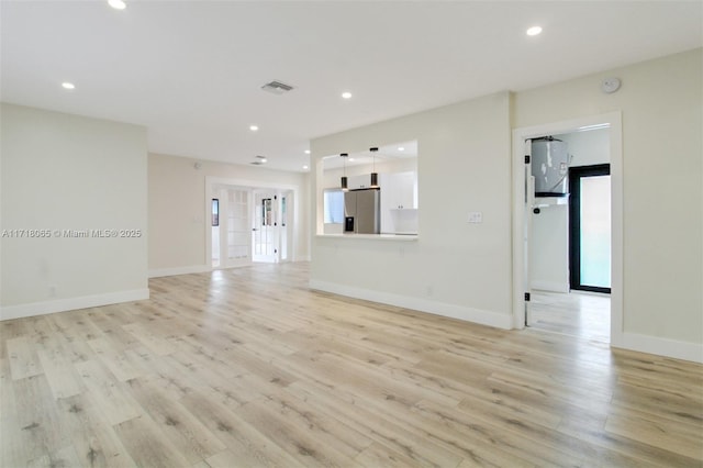 unfurnished living room featuring light hardwood / wood-style floors and a healthy amount of sunlight