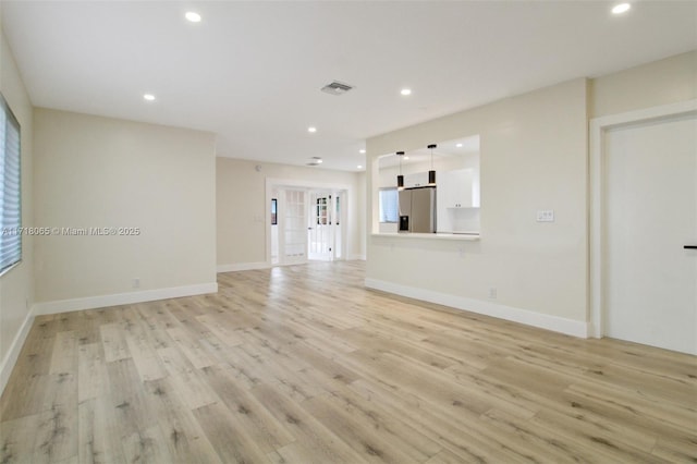 unfurnished living room featuring light hardwood / wood-style floors and a wealth of natural light