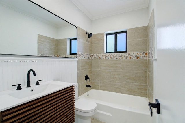 full bathroom with vanity, toilet, ornamental molding, and tiled shower / bath combo