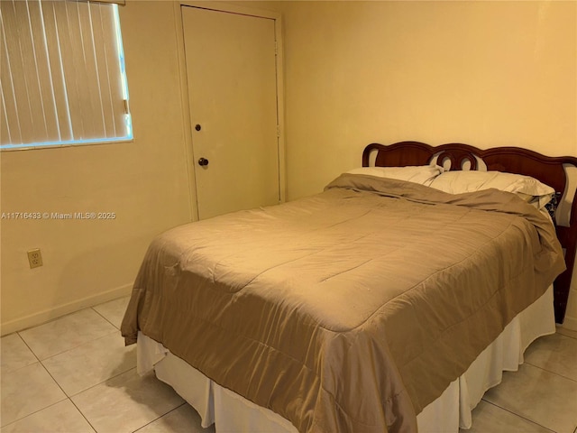 bedroom with a closet and light tile patterned flooring