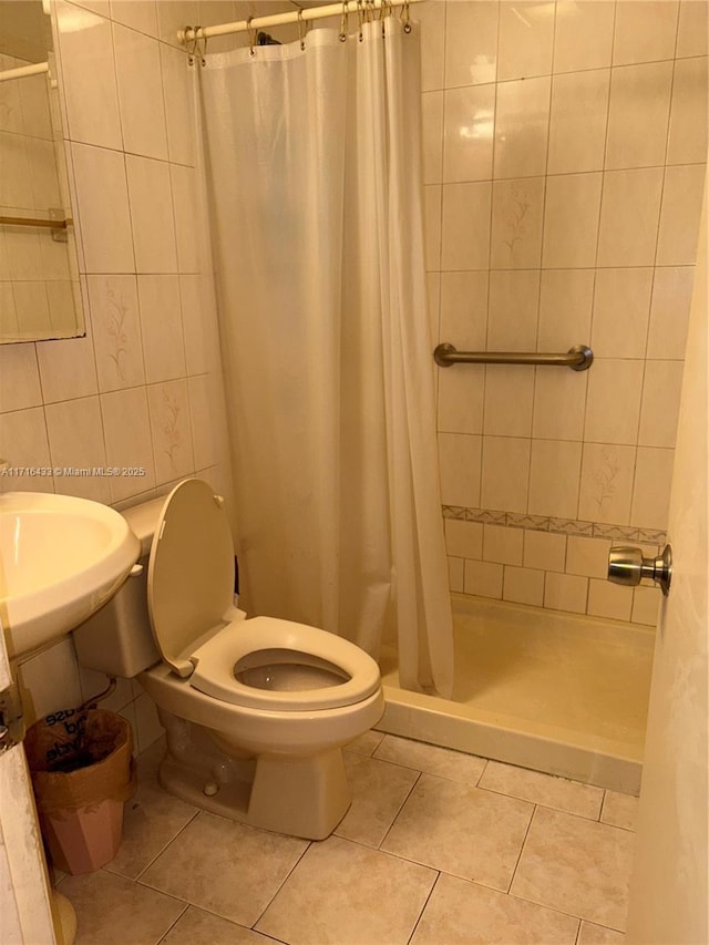 bathroom featuring a shower with curtain, tile patterned flooring, tile walls, and toilet