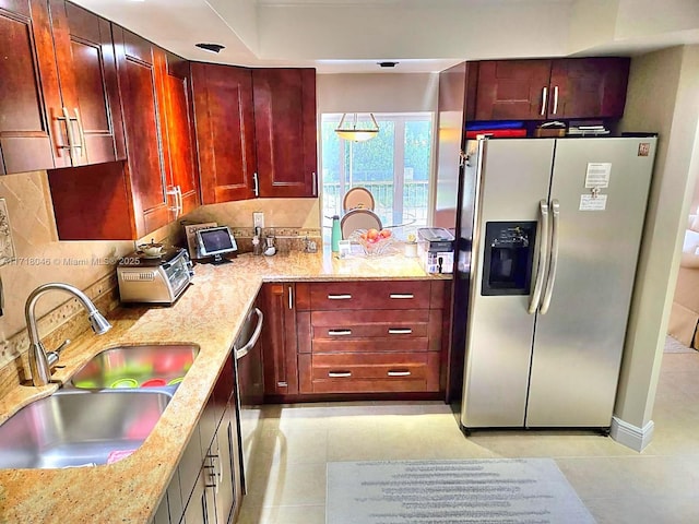 kitchen with light stone countertops, sink, light tile patterned floors, and appliances with stainless steel finishes