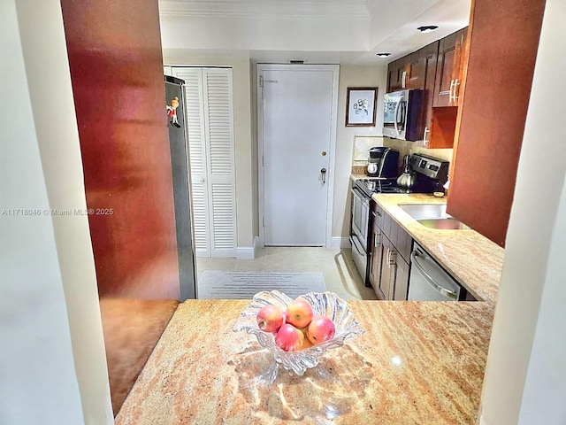 kitchen with light stone counters and appliances with stainless steel finishes