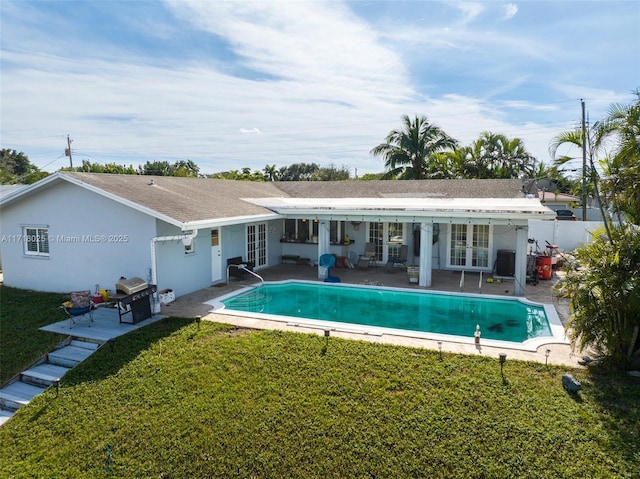 back of property featuring a yard, a patio area, and french doors