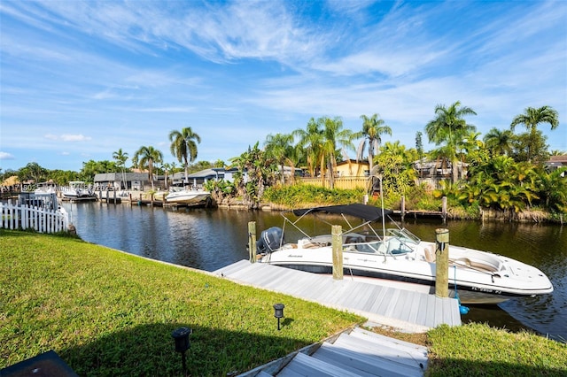 dock area featuring a lawn and a water view