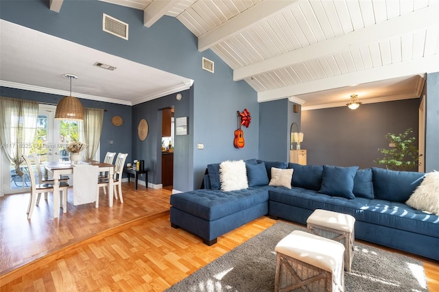 living room featuring hardwood / wood-style floors, vaulted ceiling with beams, and ornamental molding