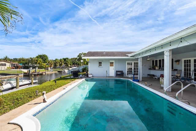 view of swimming pool with a patio area and a water view