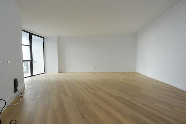 unfurnished room with light wood-type flooring and expansive windows