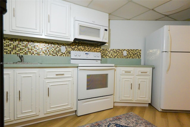 kitchen featuring white cabinets, white appliances, and a drop ceiling