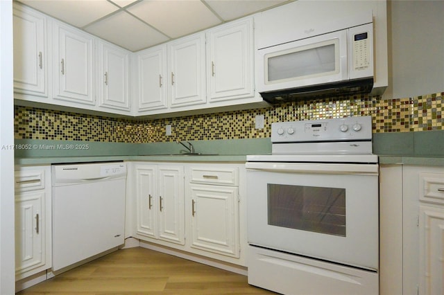 kitchen featuring white cabinets, decorative backsplash, white appliances, and a drop ceiling