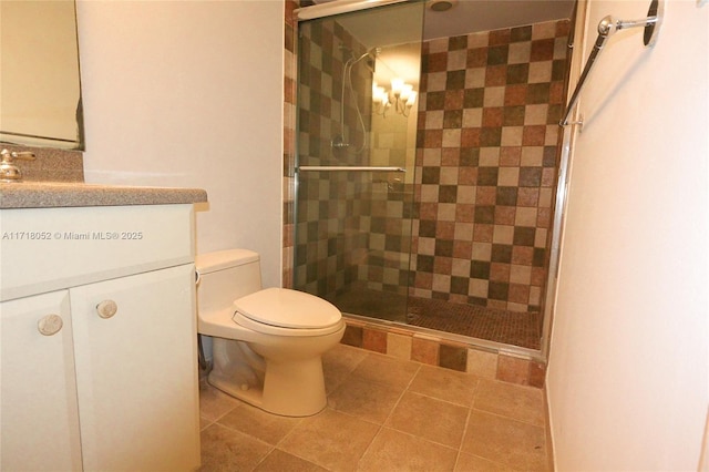 bathroom featuring vanity, a shower with shower door, and toilet