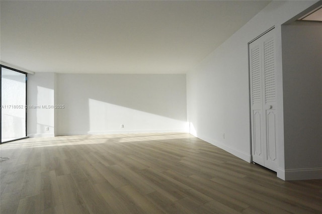 unfurnished bedroom featuring dark hardwood / wood-style flooring and floor to ceiling windows