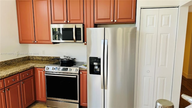 kitchen featuring dark stone countertops and stainless steel appliances