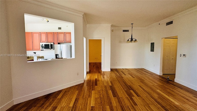 unfurnished living room featuring hardwood / wood-style floors and ornamental molding