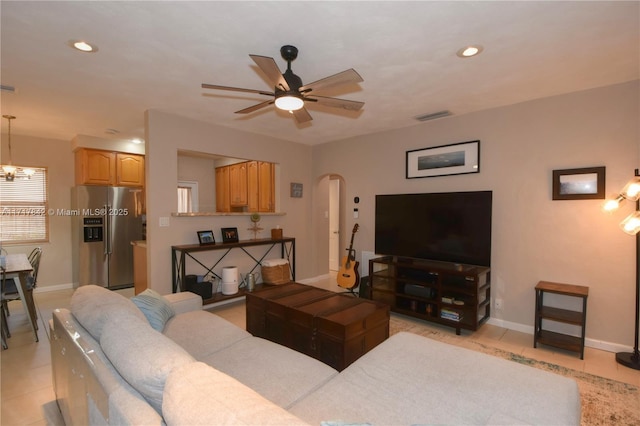 living room featuring ceiling fan with notable chandelier and light tile patterned flooring