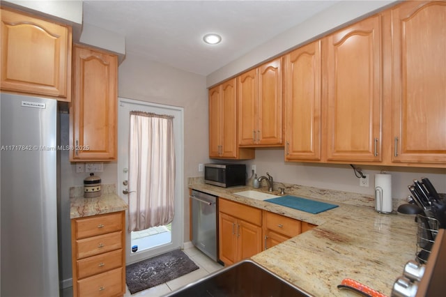 kitchen featuring light stone countertops, sink, light tile patterned flooring, and stainless steel appliances