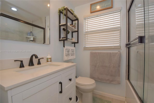 full bathroom featuring vanity, toilet, and bath / shower combo with glass door