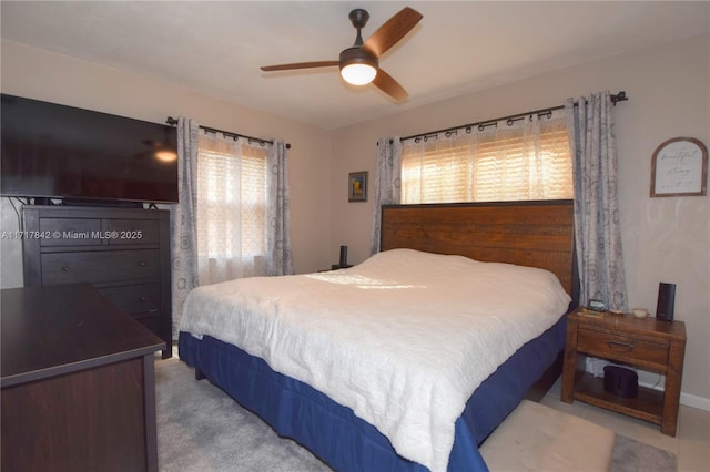 carpeted bedroom featuring multiple windows and ceiling fan