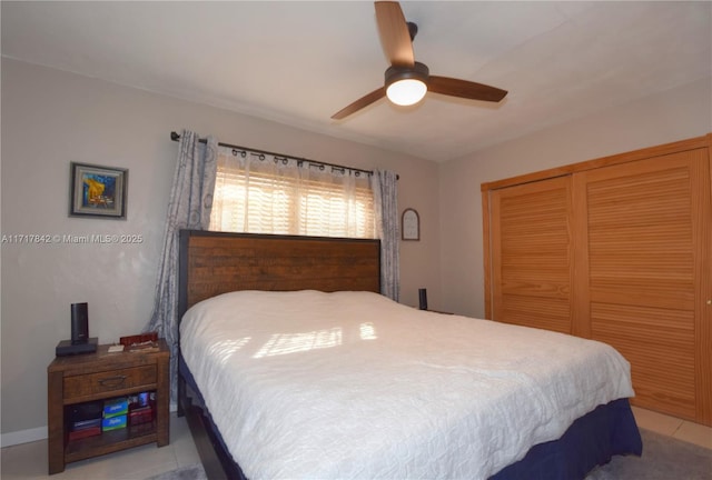 bedroom featuring light tile patterned floors, a closet, and ceiling fan