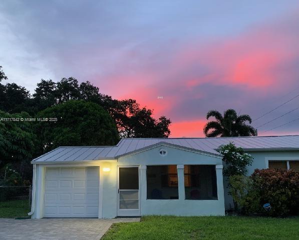 view of front of home with a garage and a yard