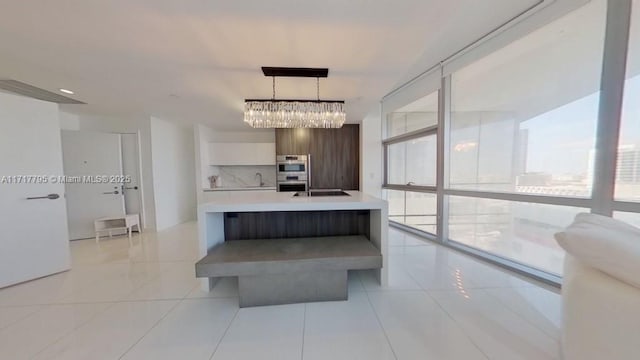 kitchen featuring light tile patterned floors, double oven, light countertops, hanging light fixtures, and modern cabinets