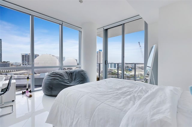 tiled bedroom featuring a view of city, access to outside, expansive windows, and multiple windows