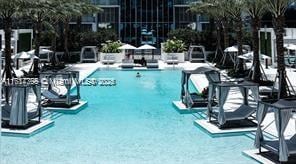 community pool featuring a patio area and a water play area