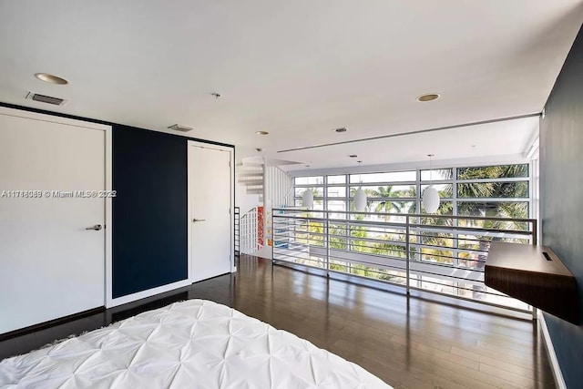 bedroom featuring dark hardwood / wood-style flooring and expansive windows