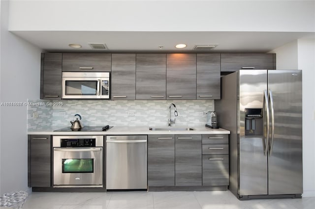 kitchen featuring decorative backsplash, stainless steel appliances, and sink