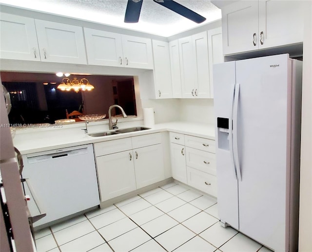 kitchen with light tile patterned flooring, white cabinetry, sink, and white appliances