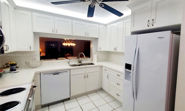 kitchen with white appliances, light countertops, a sink, and white cabinetry