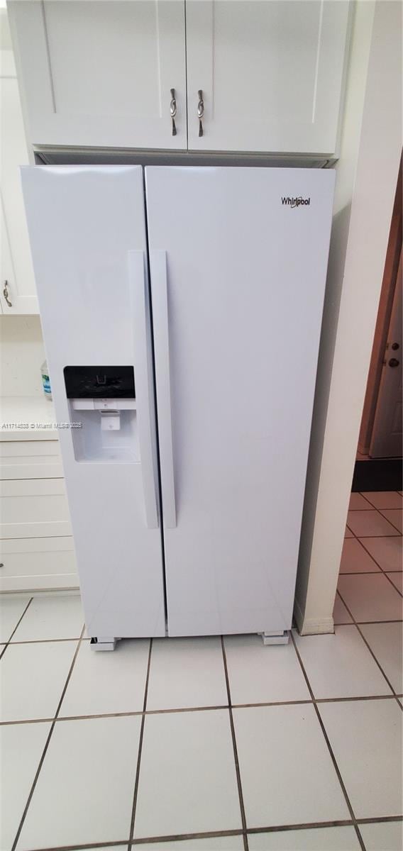 room details with white fridge with ice dispenser and white cabinetry