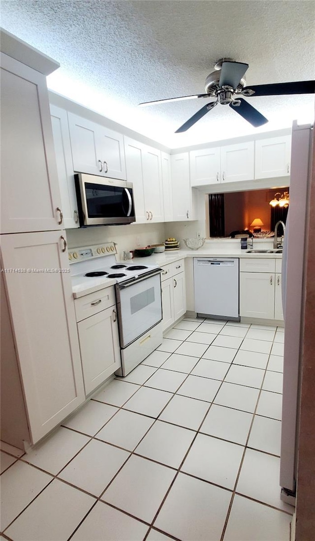 kitchen with a textured ceiling, ceiling fan, white cabinetry, light countertops, and appliances with stainless steel finishes