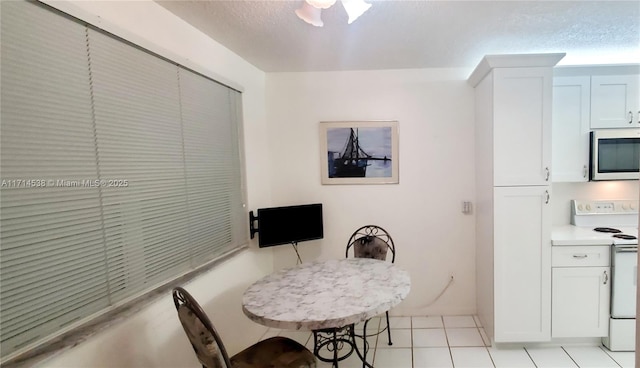 tiled dining space with ceiling fan and a textured ceiling