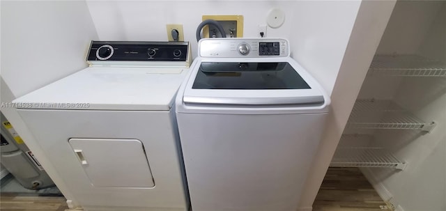 laundry area with laundry area, separate washer and dryer, and wood finished floors