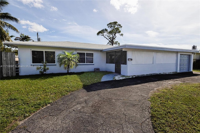 ranch-style home featuring a garage and a front lawn