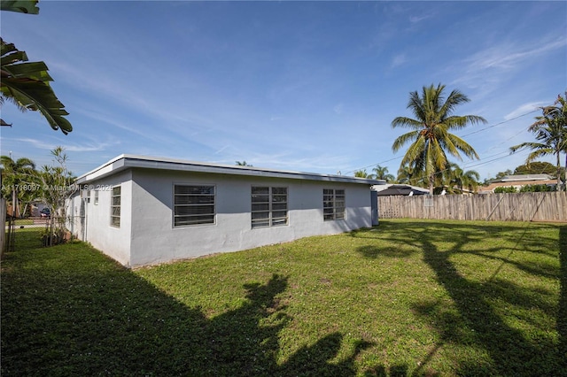 rear view of property featuring a lawn