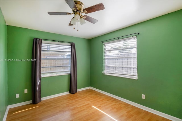 spare room with wood-type flooring, plenty of natural light, and ceiling fan