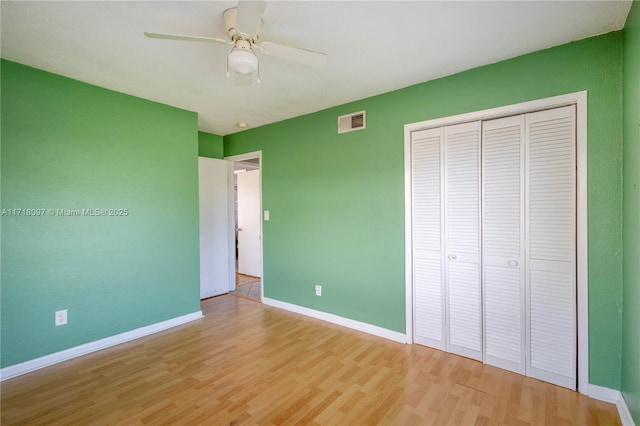 unfurnished bedroom featuring ceiling fan, light hardwood / wood-style flooring, and a closet