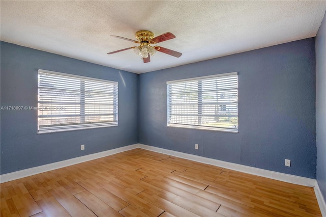 spare room with a textured ceiling, hardwood / wood-style flooring, and ceiling fan