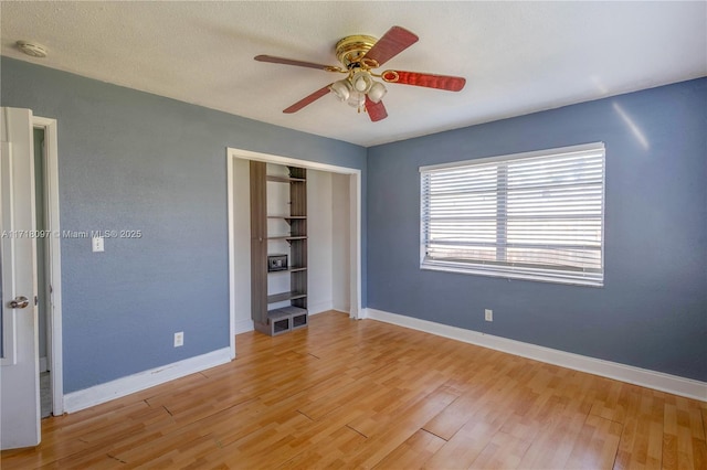 unfurnished bedroom with light wood-type flooring, a closet, and ceiling fan