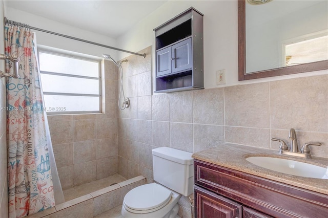 bathroom with a shower with shower curtain, vanity, toilet, and tile walls