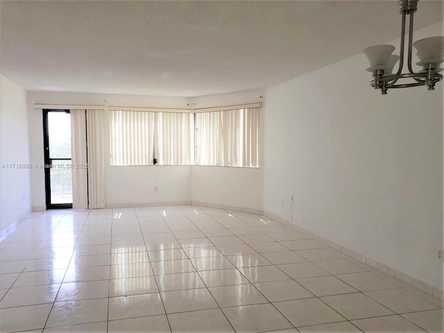 tiled empty room with a chandelier