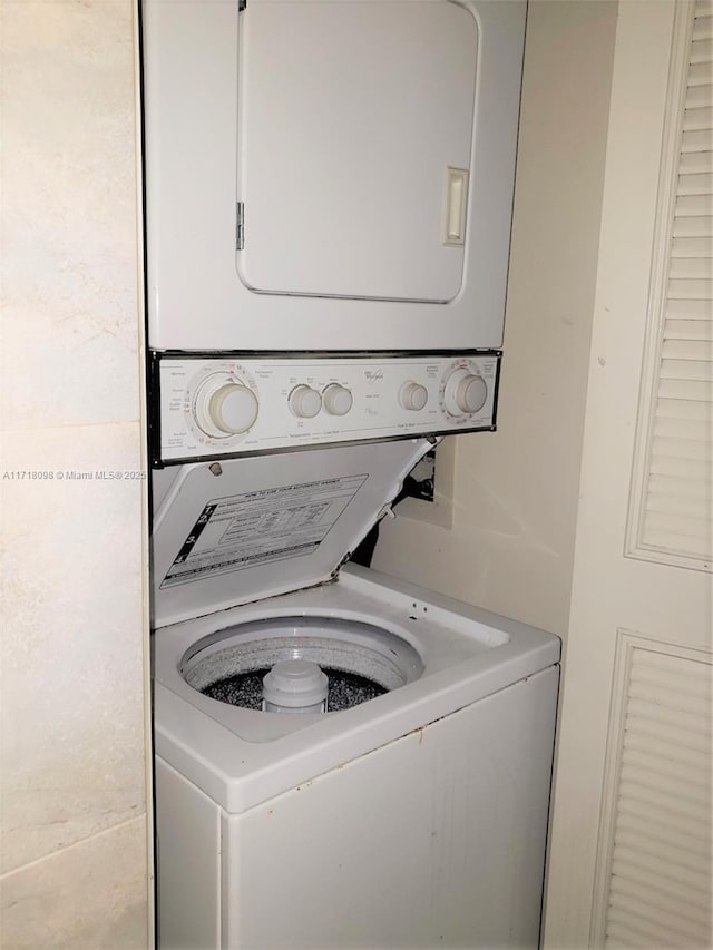 washroom featuring stacked washer / drying machine