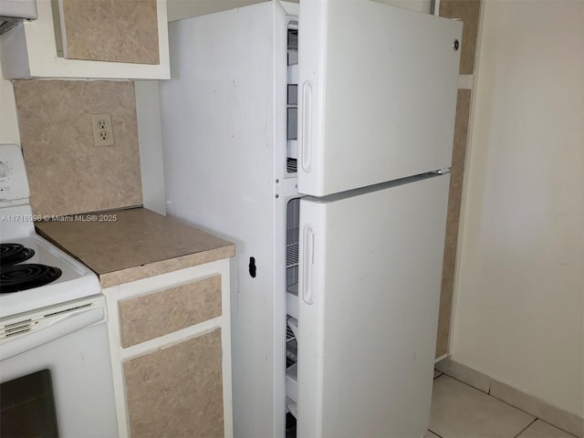 kitchen with decorative backsplash, light tile patterned floors, and white appliances