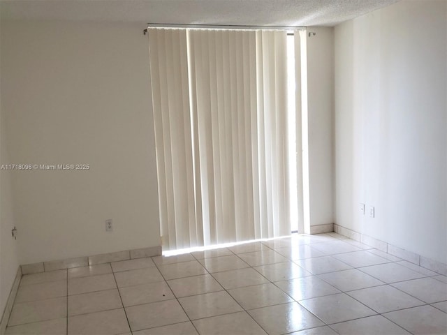 empty room featuring light tile patterned floors and a textured ceiling