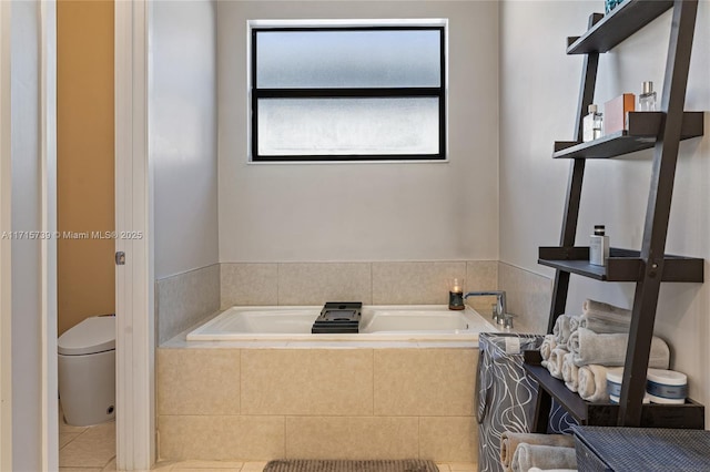 bathroom with tile patterned floors, a relaxing tiled tub, and toilet