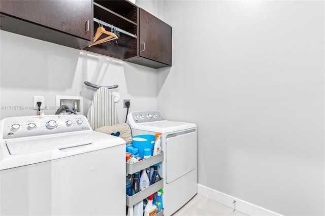 laundry room featuring cabinets, separate washer and dryer, and light tile patterned floors