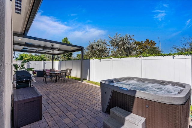 view of patio with area for grilling and a hot tub